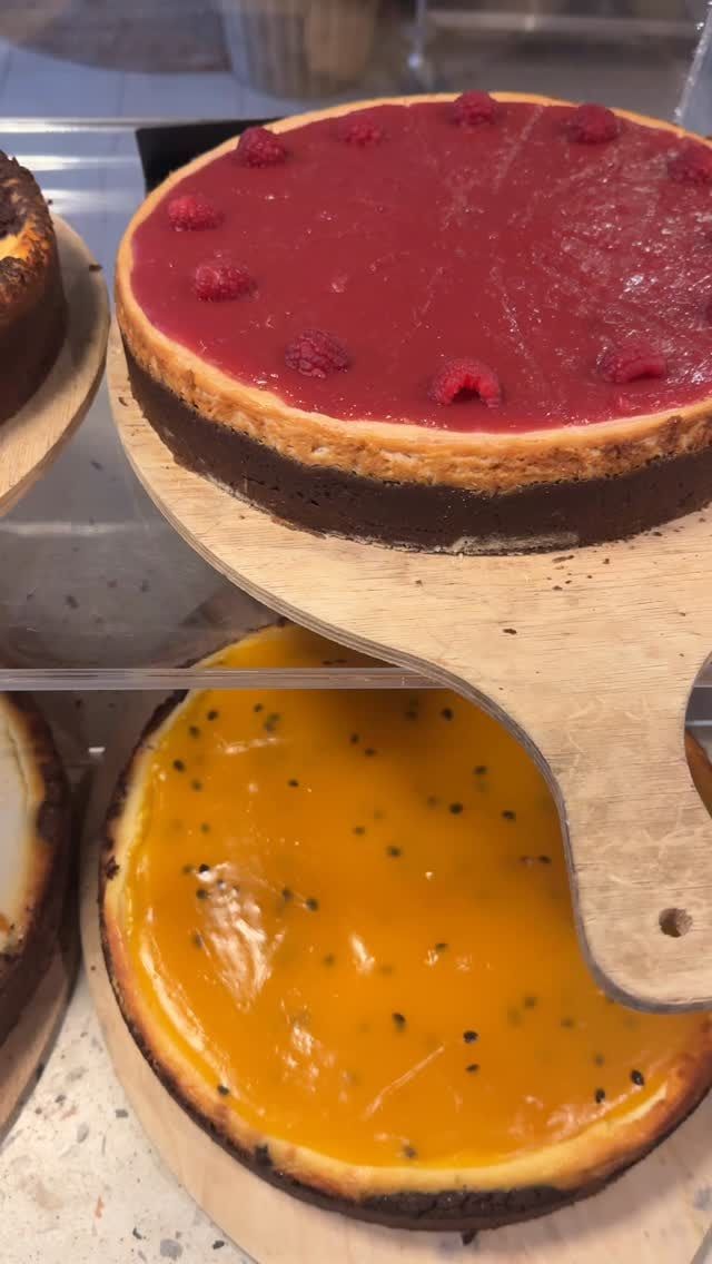 Käsekuchen mit Himbeer- und Maracujaspiegel auf Holzbrettern in der Theke